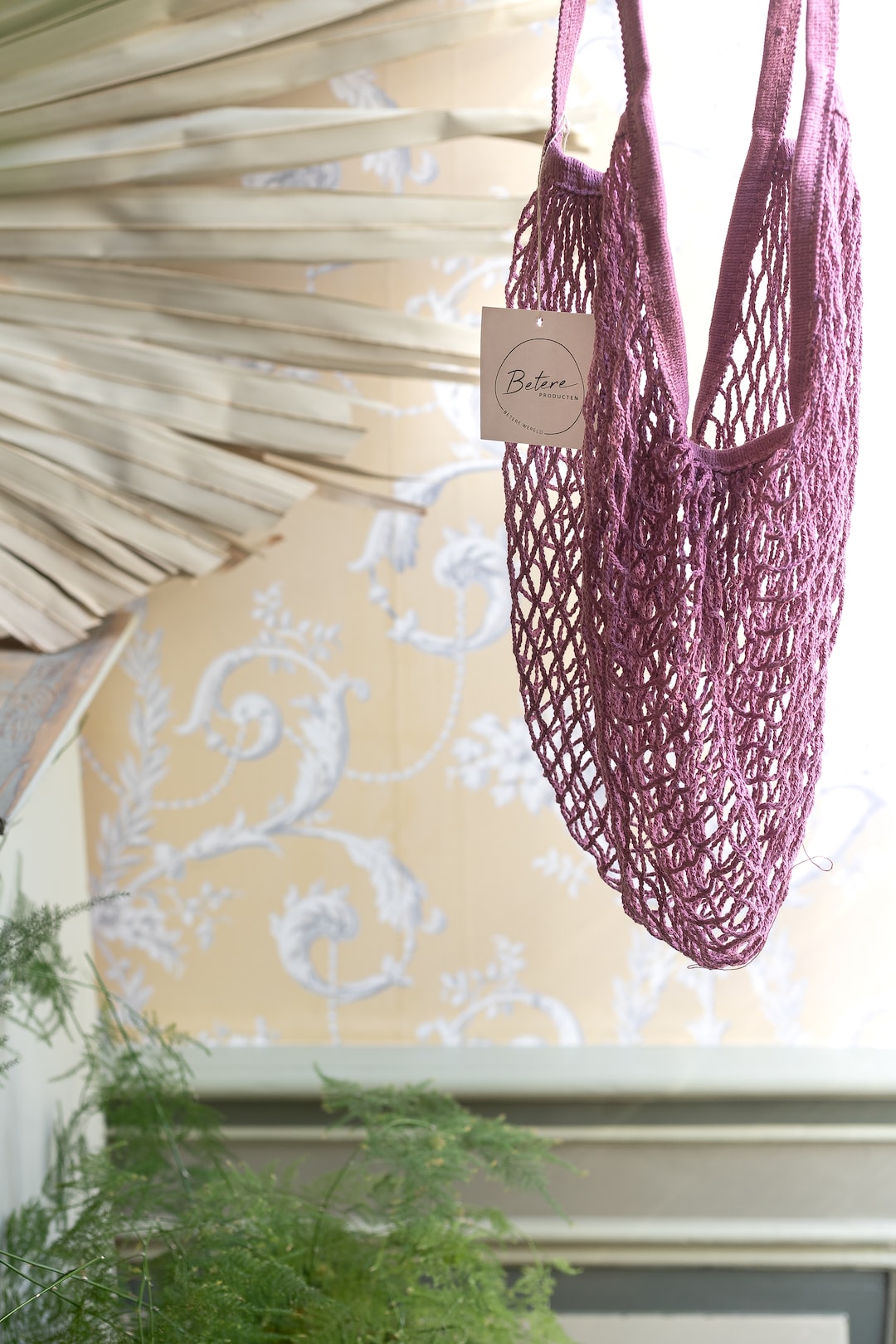 a purple bag hanging from a ceiling next to a potted plant
