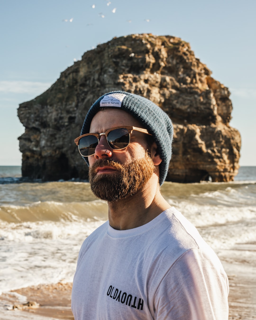 a man with a beard wearing sunglasses and a hat