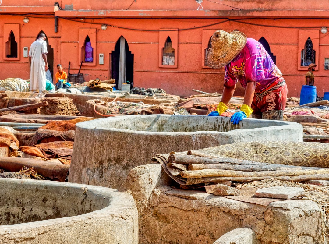 Worker at a tannery in Morocco.
A visit to a Moroccan tannery is not only a visual impression that stays, also the smell is unforgettable. The procedure of making leather has not changed much over the last decades and even centuries, neither have the working conditions, we were told. In Marrakesh the tannery is an enterprise run by about 50 families. The reputation of Moroccan leather was so great that the French word woman in pink and yellow dress holding fish net